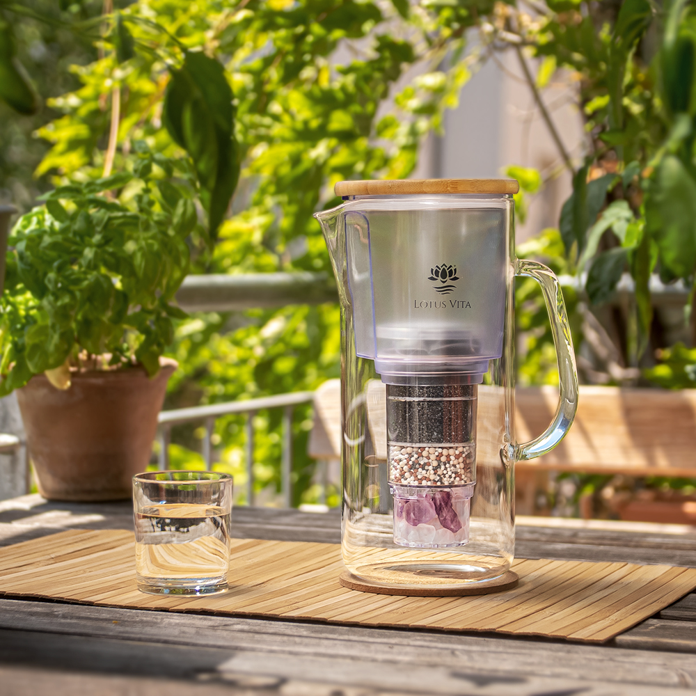 Impression: NATURA PLUS Glas-Filterkanne ENYA mit Bambus-Deckel und Filter auf einem Tisch.
