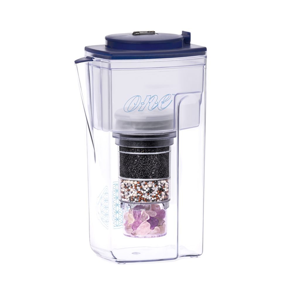 Transparente Wasserfilter-Kanne mit blauem Deckel, sichtbarer mehrschichtiger Filterkartusche und einem Fach für Kristalle am Boden.