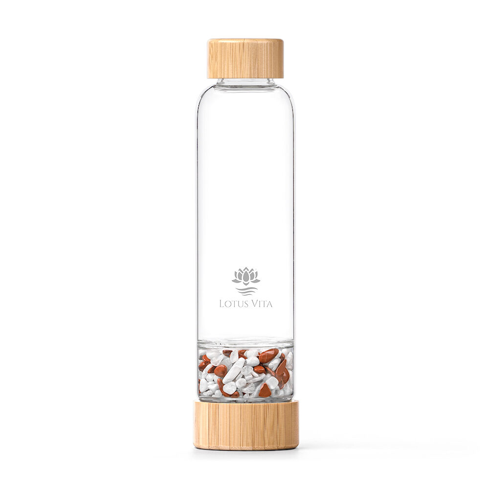 Eine Glas-Trinkflasche mit Bambusdeckel und separatem Fach, gefüllt mit roten Jaspis- und Milchopal-Edelsteinen.