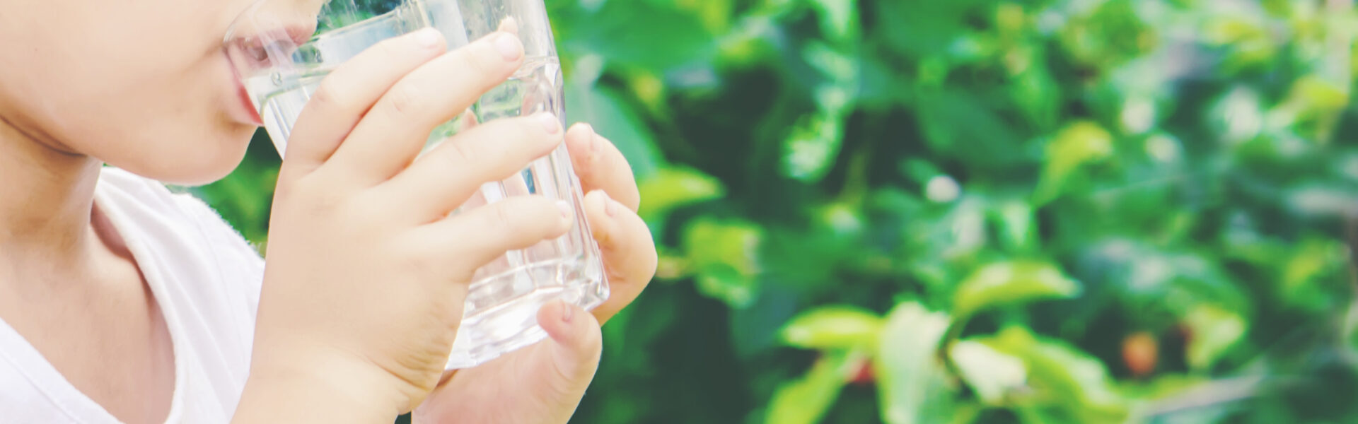 Kind trinkt aus Wasserglas.