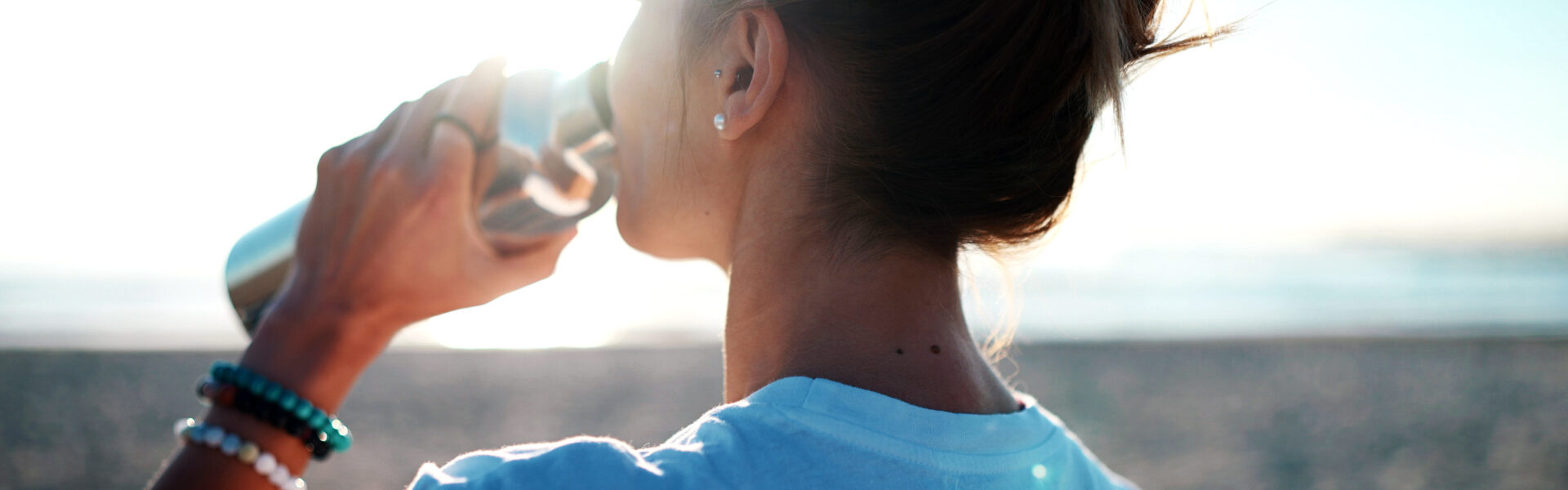 Frau trinkt aus Wasserflasche.