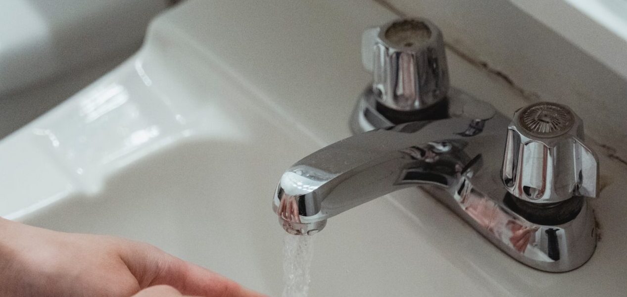 Hände werden unter Wasserhahn gewaschen.