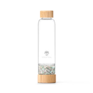 Eine Glas-Trinkflasche mit Bambusdeckel und einem separaten Fach, das mit hellgrünen und rosafarbenen Kristallsteinen gefüllt ist.