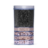 Eine transparente Wasserfilter-Kartusche, die in mehreren Schichten mit verschiedenen Filtergranulaten und Mineralkugeln gefüllt ist.